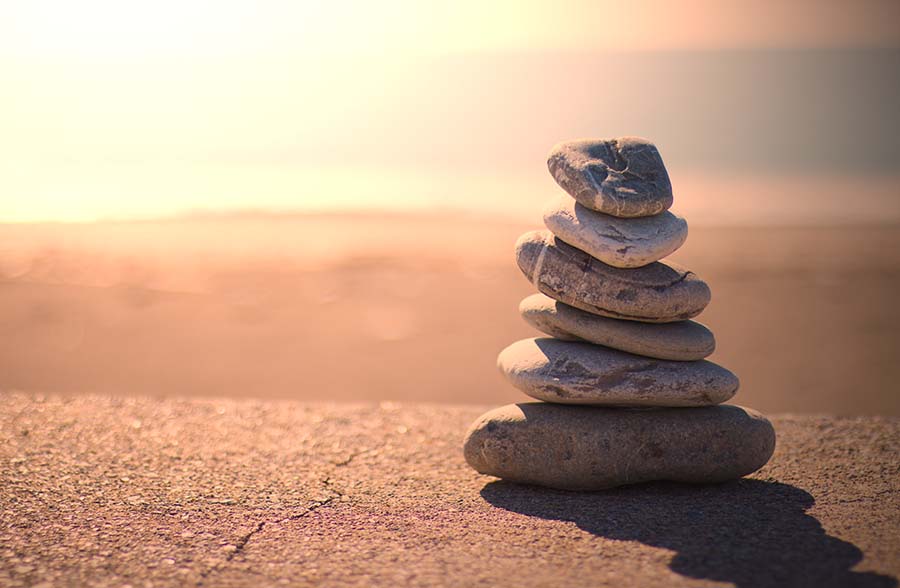 Symbolfoto Steinpyramide auf Wüstenboden © Adobe Stock